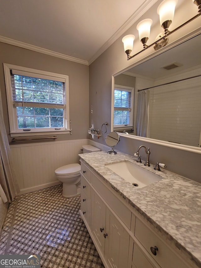 bathroom with toilet, tile patterned floors, vanity, and ornamental molding