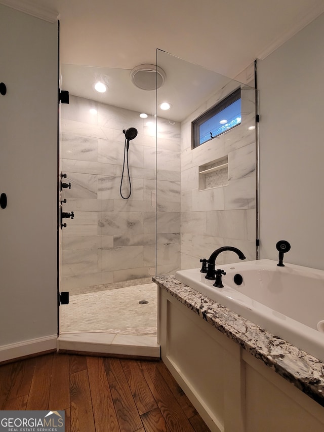 bathroom with separate shower and tub, hardwood / wood-style flooring, and ornamental molding