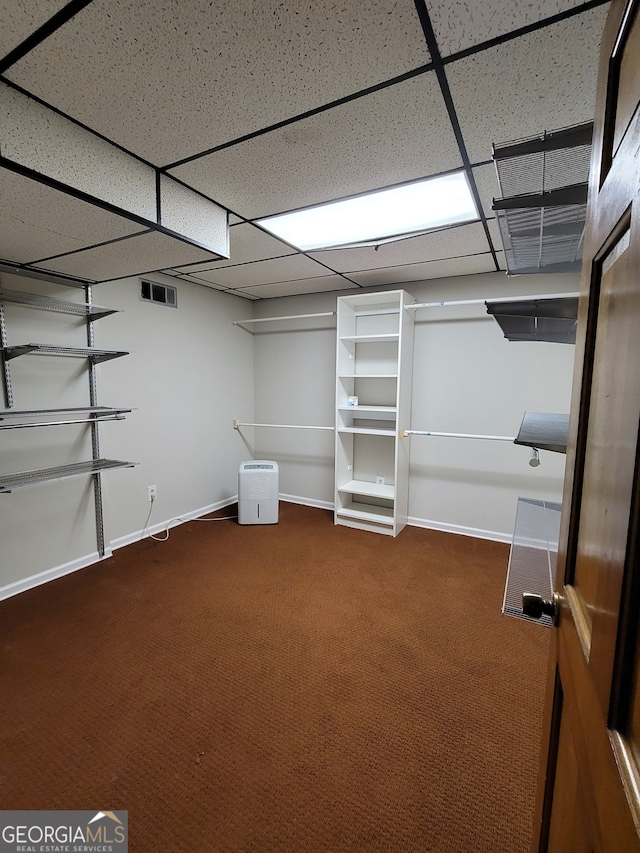 basement with a paneled ceiling and carpet flooring