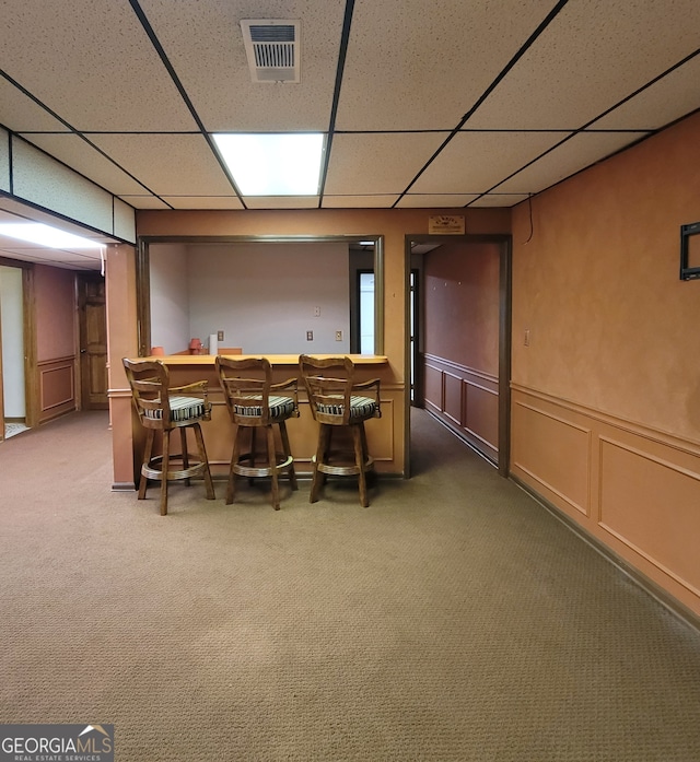 home theater featuring indoor bar, a drop ceiling, and carpet