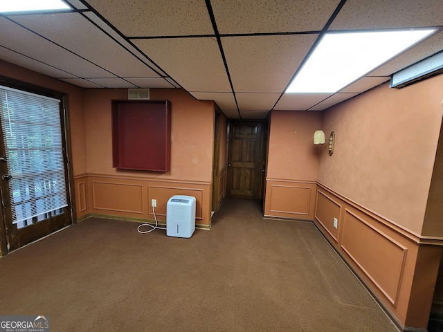 basement featuring a drop ceiling and carpet floors