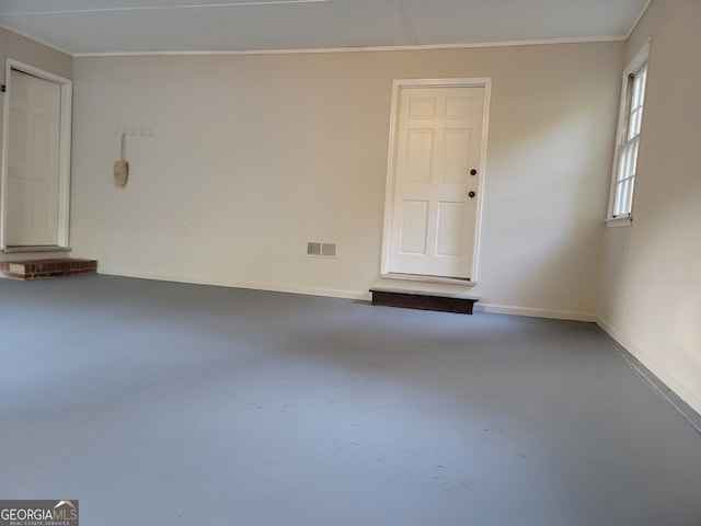 spare room with crown molding and concrete floors