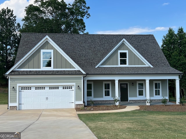 craftsman house with covered porch, a garage, and a front lawn