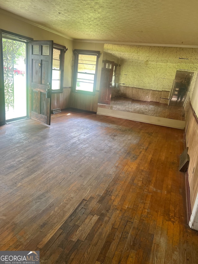 unfurnished living room featuring hardwood / wood-style flooring and a textured ceiling