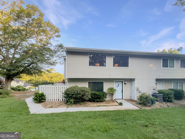 view of front of home featuring cooling unit and a front lawn