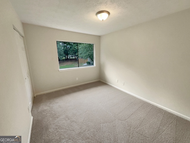 carpeted spare room featuring a textured ceiling