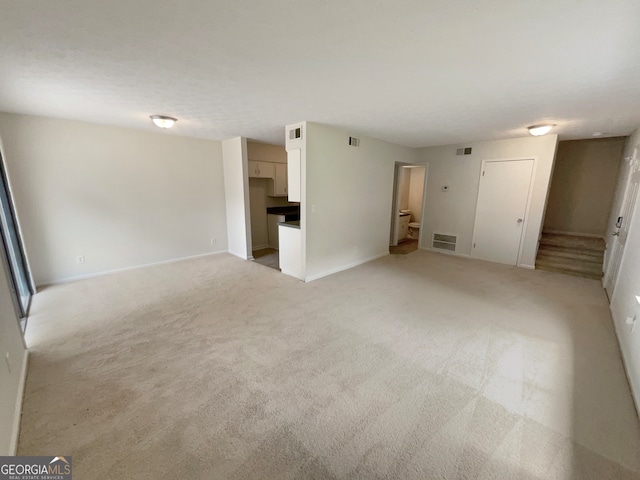 unfurnished living room with light colored carpet