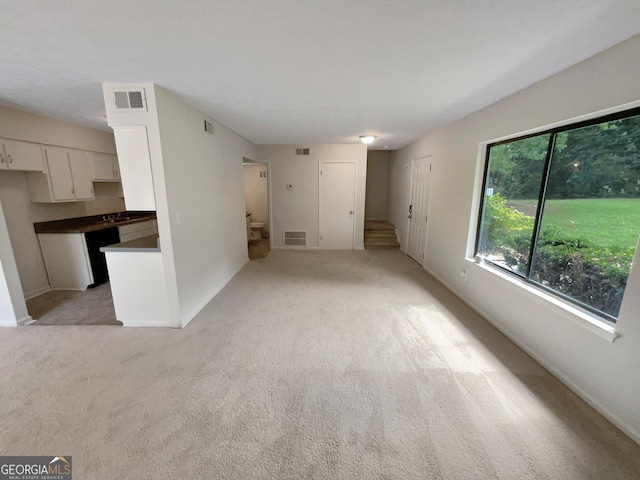 unfurnished living room with light colored carpet