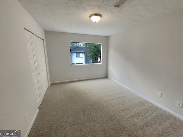 unfurnished room featuring carpet floors and a textured ceiling