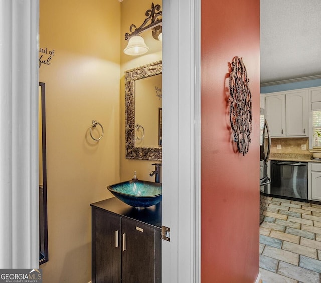 bathroom featuring vanity and tasteful backsplash