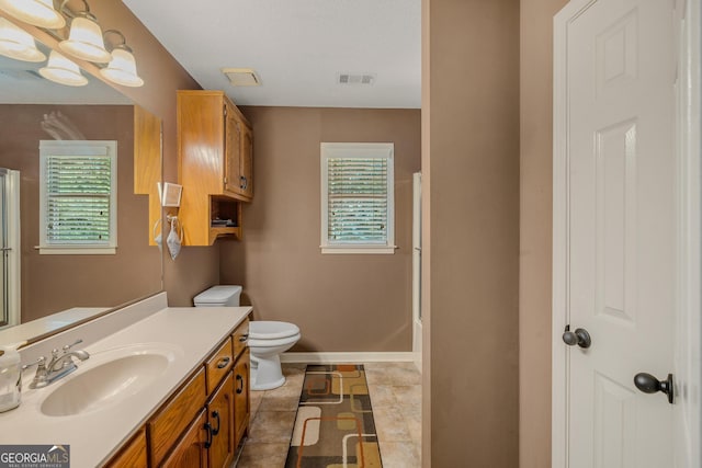 bathroom featuring vanity, toilet, an enclosed shower, and tile patterned flooring