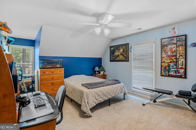 carpeted bedroom featuring ceiling fan, vaulted ceiling, and a textured ceiling