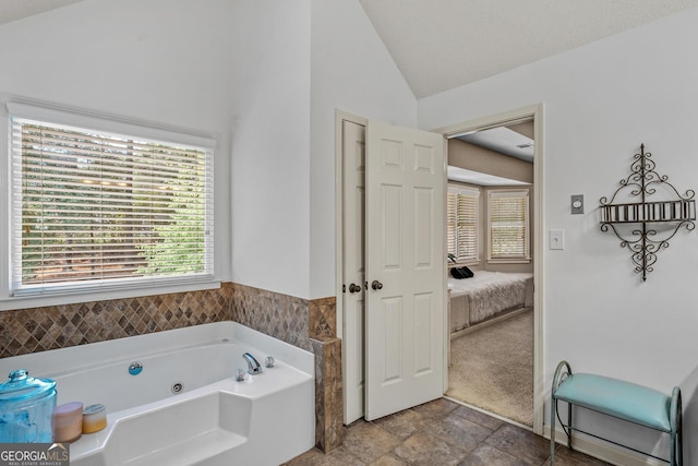 bathroom featuring a washtub and vaulted ceiling