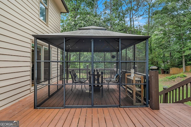 wooden terrace featuring a gazebo and a sunroom