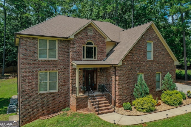 view of front facade with a porch, central AC unit, and a front lawn