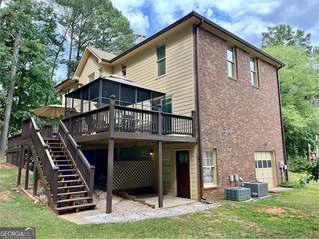 rear view of property with a wooden deck, a garage, central AC unit, and a sunroom