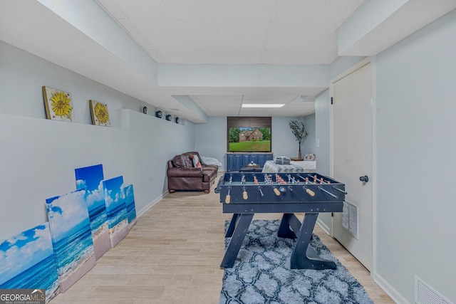 playroom with a drop ceiling and light hardwood / wood-style flooring