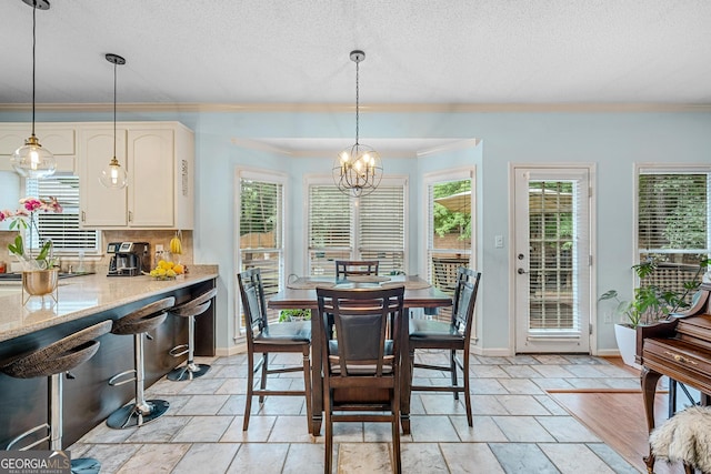 dining area featuring ornamental molding, a healthy amount of sunlight, a notable chandelier, and a textured ceiling