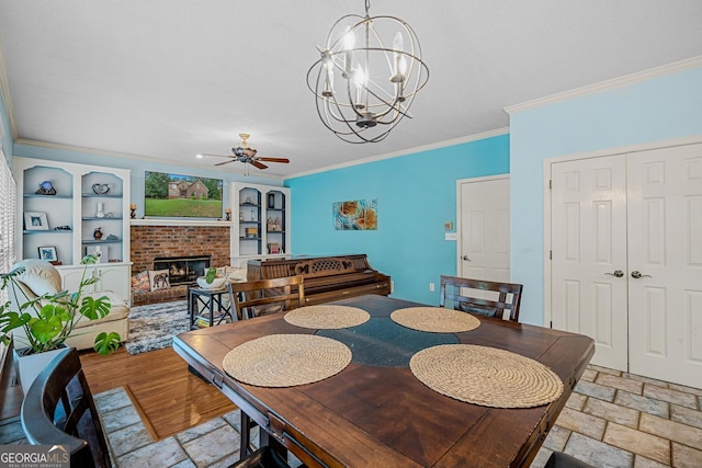 dining space with crown molding, a brick fireplace, and ceiling fan with notable chandelier