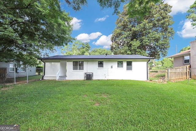 rear view of property with a yard