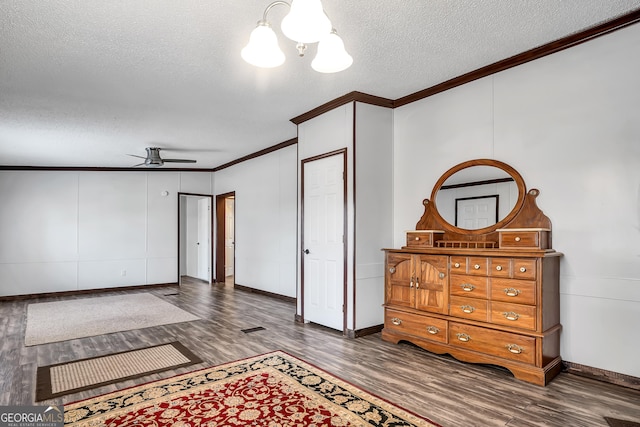 bedroom featuring a notable chandelier, crown molding, dark hardwood / wood-style floors, and a textured ceiling