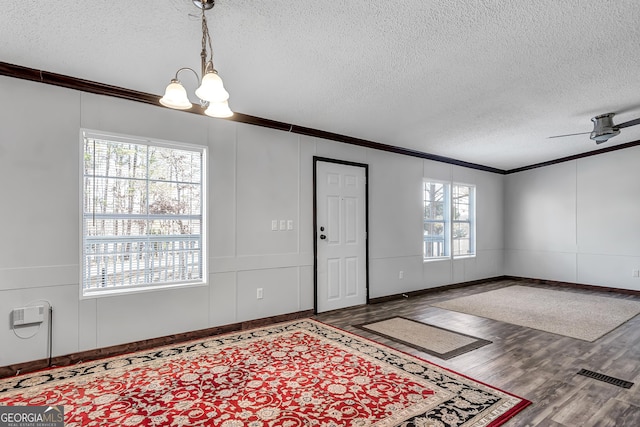 foyer with ceiling fan with notable chandelier, crown molding, a textured ceiling, and wood-type flooring