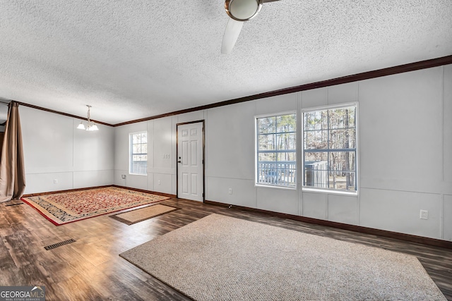 entryway featuring crown molding, a chandelier, a textured ceiling, and dark hardwood / wood-style flooring