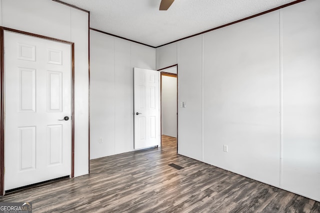 unfurnished bedroom with ceiling fan, dark hardwood / wood-style floors, and a textured ceiling