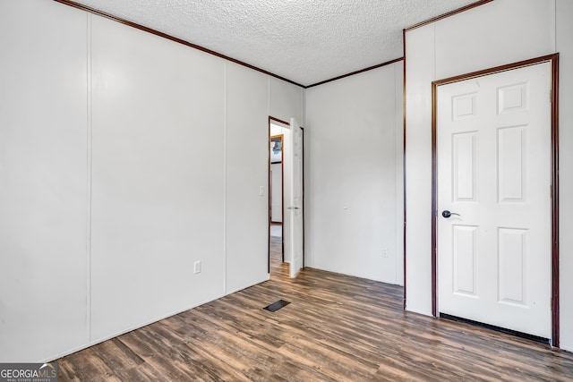 empty room featuring dark wood-type flooring and a textured ceiling