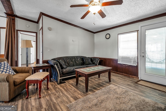 living room featuring ceiling fan, a textured ceiling, dark hardwood / wood-style floors, and ornamental molding