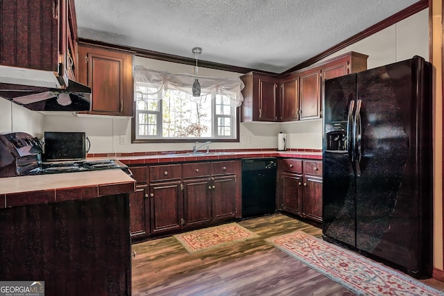 kitchen featuring crown molding, hanging light fixtures, sink, light hardwood / wood-style floors, and black appliances