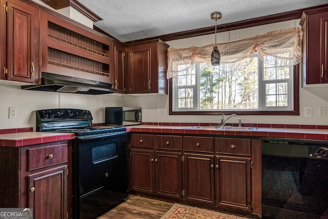 kitchen featuring a textured ceiling, black appliances, sink, hanging light fixtures, and crown molding