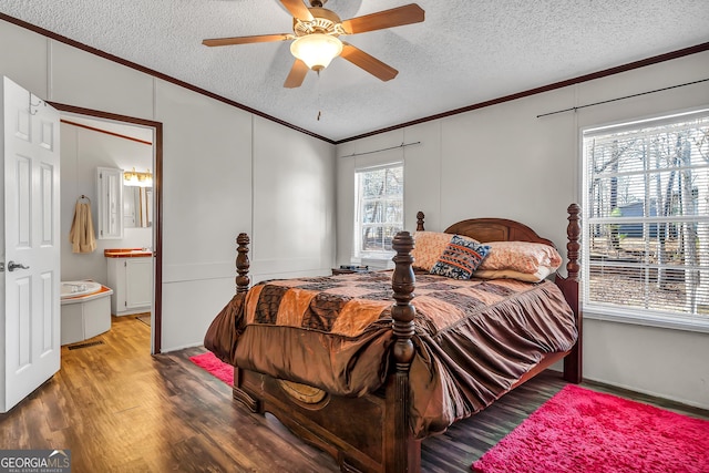 bedroom with ceiling fan, multiple windows, wood-type flooring, and ensuite bath