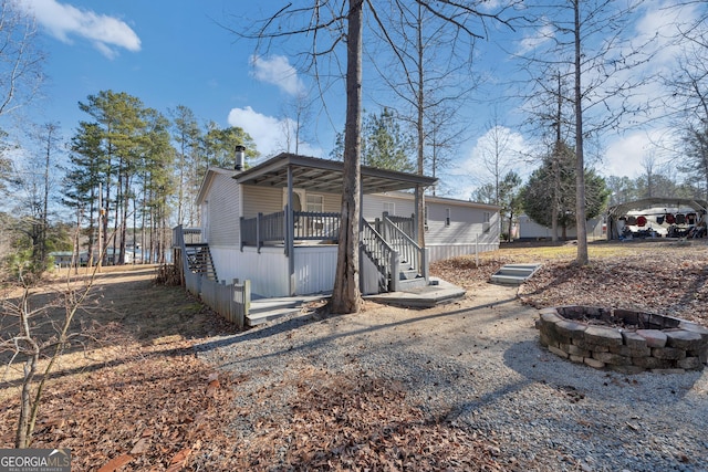 rear view of property featuring a fire pit