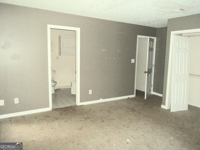 unfurnished bedroom with a closet, connected bathroom, visible vents, and baseboards