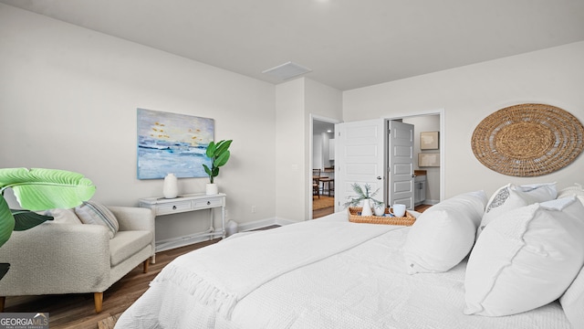 bedroom featuring dark wood-type flooring and connected bathroom