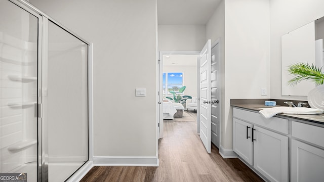 bathroom with vanity, a shower with door, and wood-type flooring