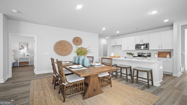 dining room featuring recessed lighting, wood finished floors, and baseboards