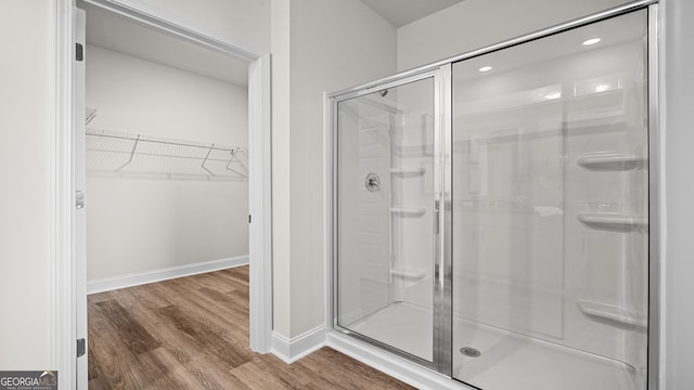 bathroom featuring wood-type flooring and a shower with shower door