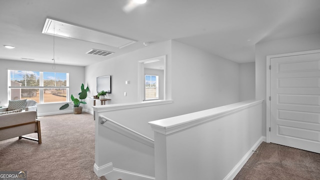 hallway featuring attic access, carpet flooring, an upstairs landing, and visible vents