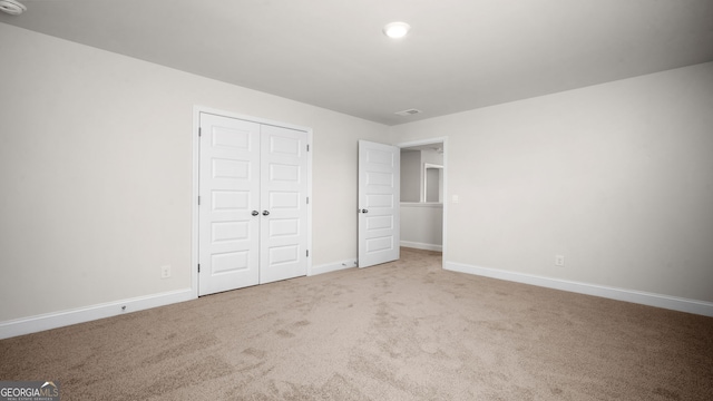 unfurnished bedroom featuring carpet floors and a closet