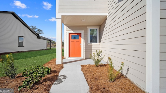 view of exterior entry featuring a yard