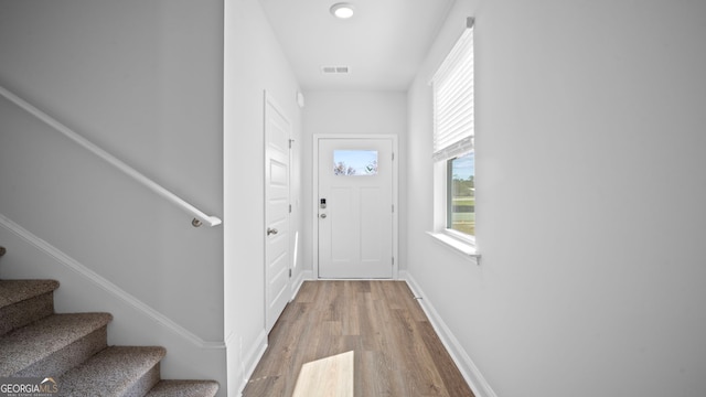 doorway to outside with stairway, baseboards, visible vents, and wood finished floors