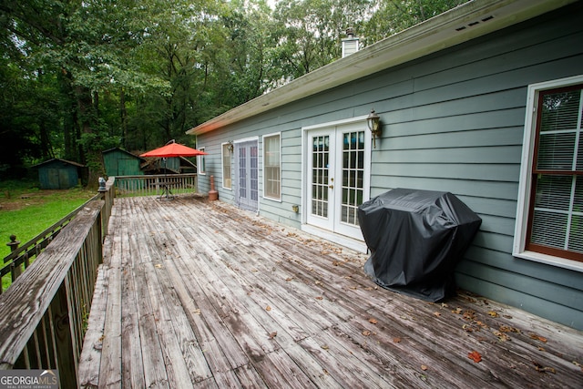 deck featuring a storage unit, area for grilling, and french doors