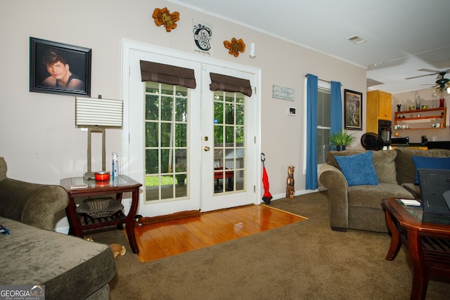 living room featuring crown molding, french doors, ceiling fan, and carpet flooring