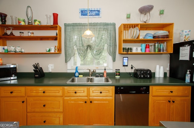 kitchen with appliances with stainless steel finishes, decorative light fixtures, and sink