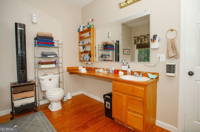 bathroom with hardwood / wood-style flooring, toilet, and vanity