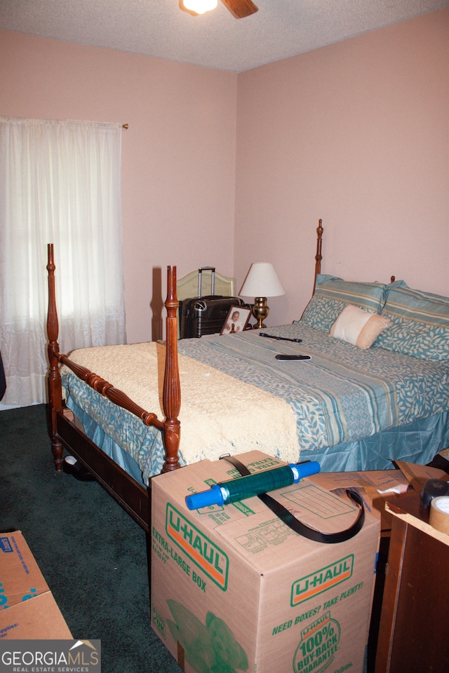 carpeted bedroom with a textured ceiling and ceiling fan