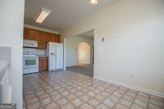 kitchen featuring light tile patterned floors and white appliances