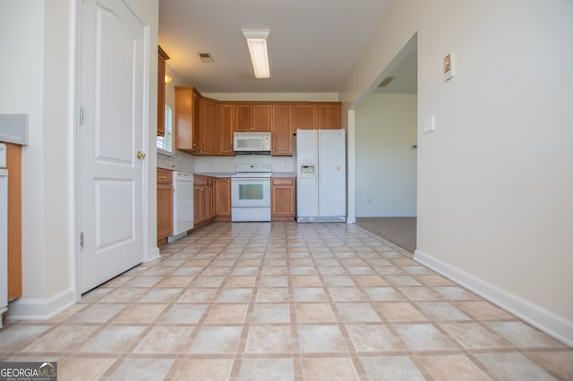 kitchen featuring light tile patterned floors and white appliances